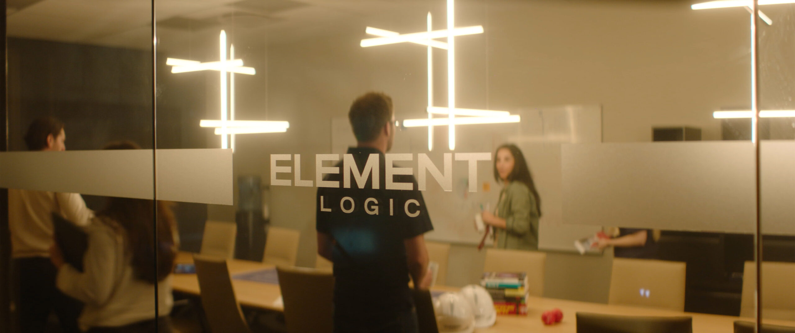 Meeting room at Element Logic seen through a glass wall with logo