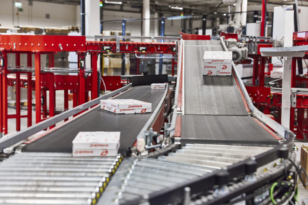 Sistema de cintas transportadoras o conveyors con cajas automatizadas en un almacén equipado con soluciones de automatización.