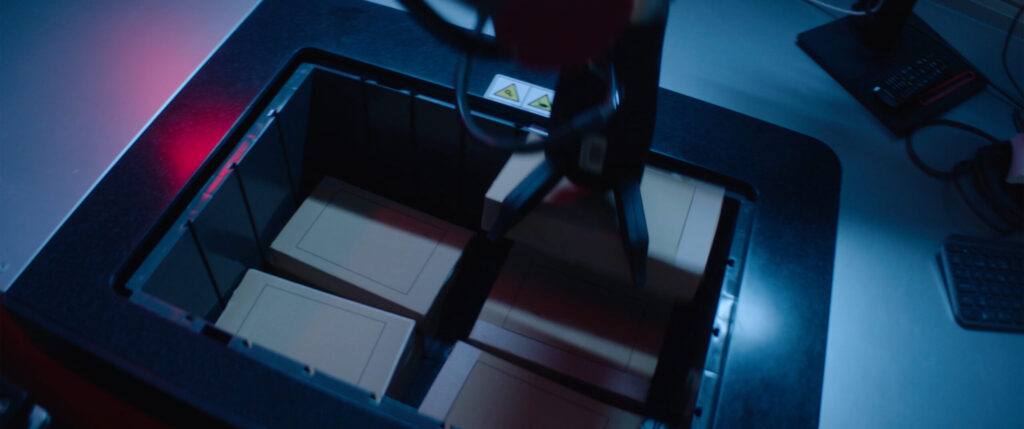 Robot de picking seleccionando cajas dentro de un contenedor en una estación automatizada.