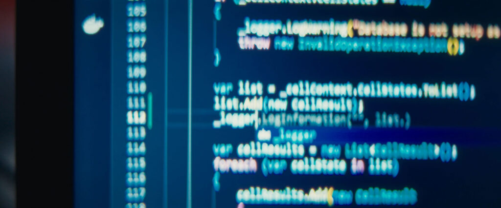 Primer plano de código en una pantalla de ordenador en un entorno técnico oscuro