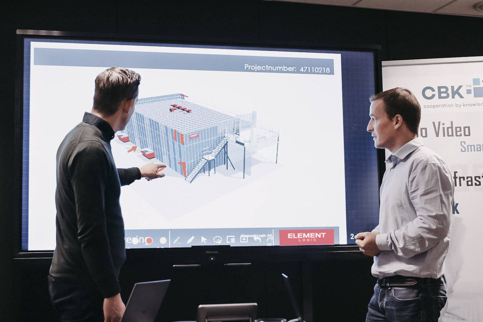 Dos profesionales de Element Logic presentan una solución de automatización de almacenes en una pantalla interactiva.