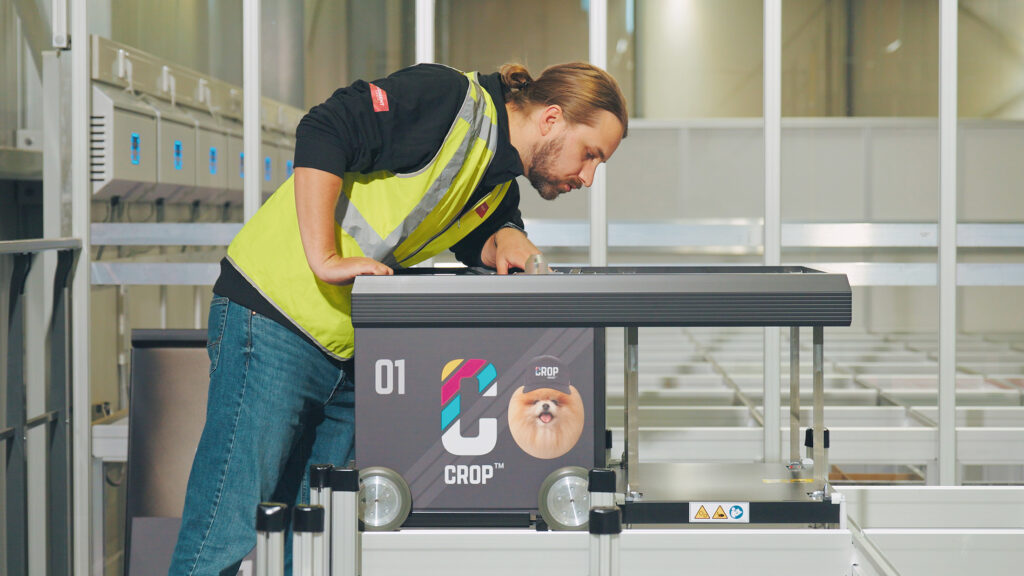 CROP warehouse with mechanic working on Element Logic robot