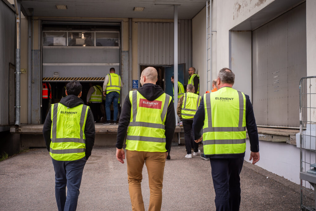 Joukko vierailijoita kävelemässä sisälle varastoon
