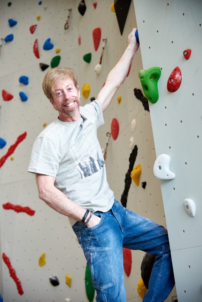 Andreas Oliver Bindhammer, the founder and CEO of eXXpozed, on a climbing wall