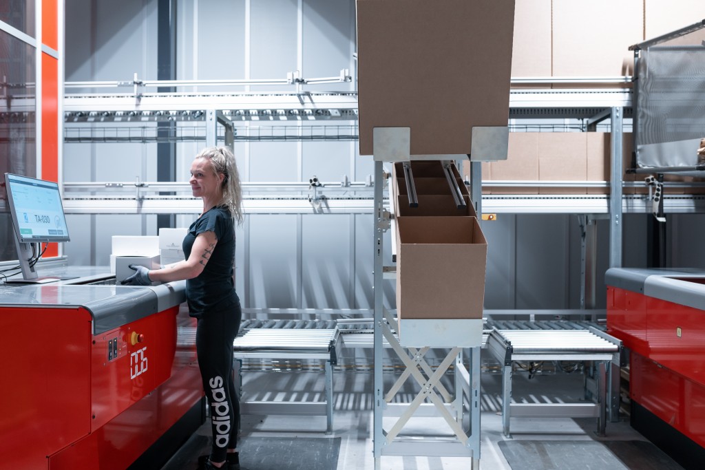 A warehouse worker is packing an order at an AutoStore port.