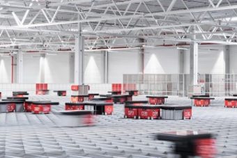 A large grid with several red AutoStore delivery robots moving across to retrieve orders.