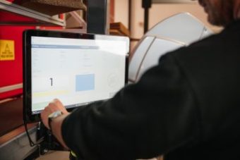 A man touches a digital screen with WMS software